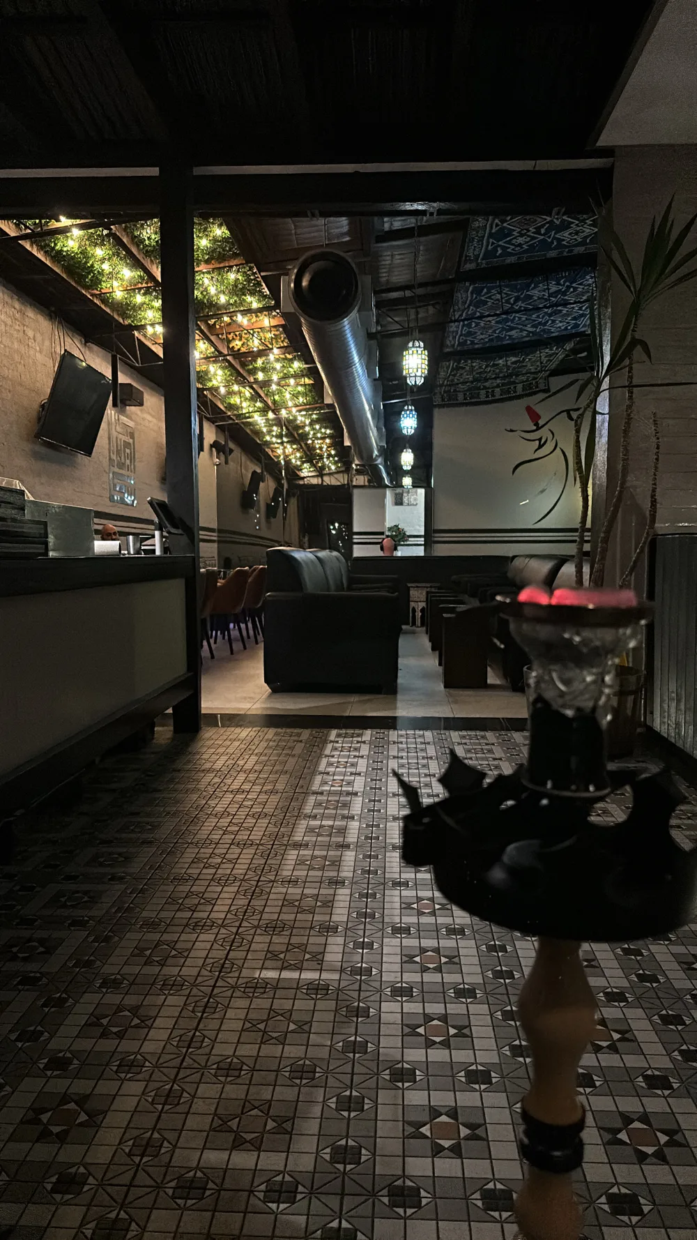 The upstairs lounge at night, with the fairy-light ceiling, lanterns and tiled floor